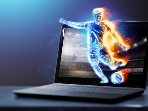 A hologram of a soccer player running out of a notebook, laptop screen. The concept of sports betting, football, gambling, online broadcast of football